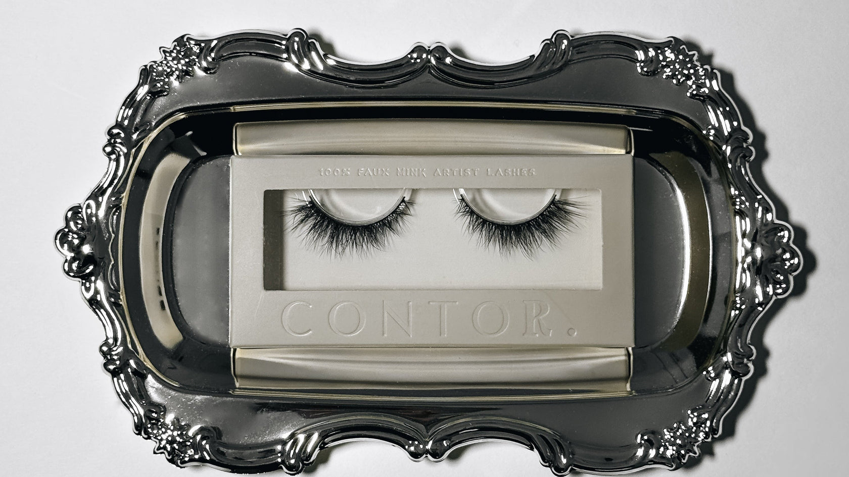 Pair of false eyelashes in a Contor case on a decorative tray